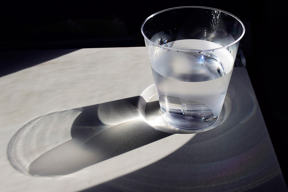 Vaso de plástico transparente lleno de agua natural sin gas
